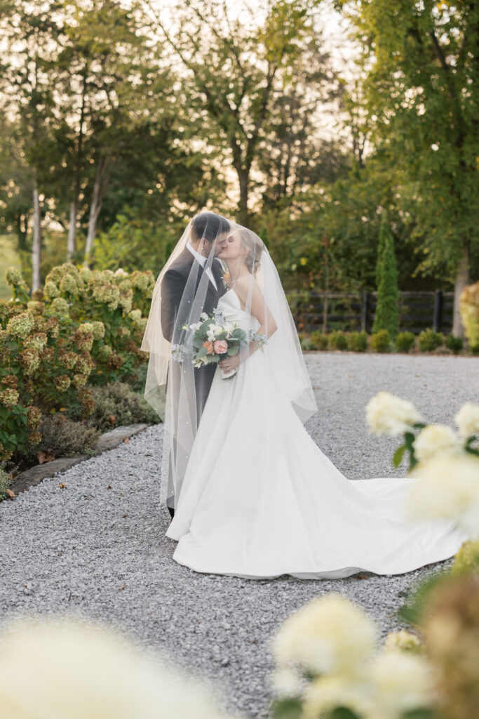 A couple taking wedding portraits during golden hour while their guest are at cocktail  hour. The photo is at Hazelnut Farm near the lake. 